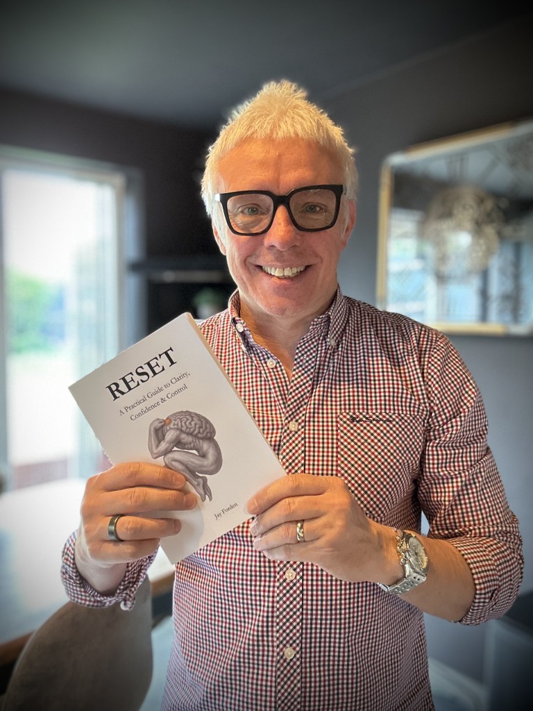 Jay Forden holding his book RESET